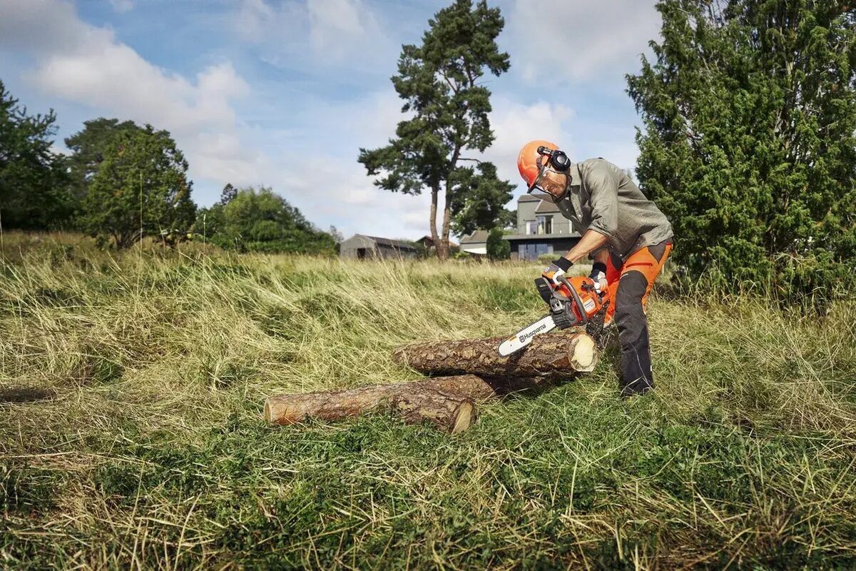Husqvarna 440 II en train de débiter des grumes dans un pré