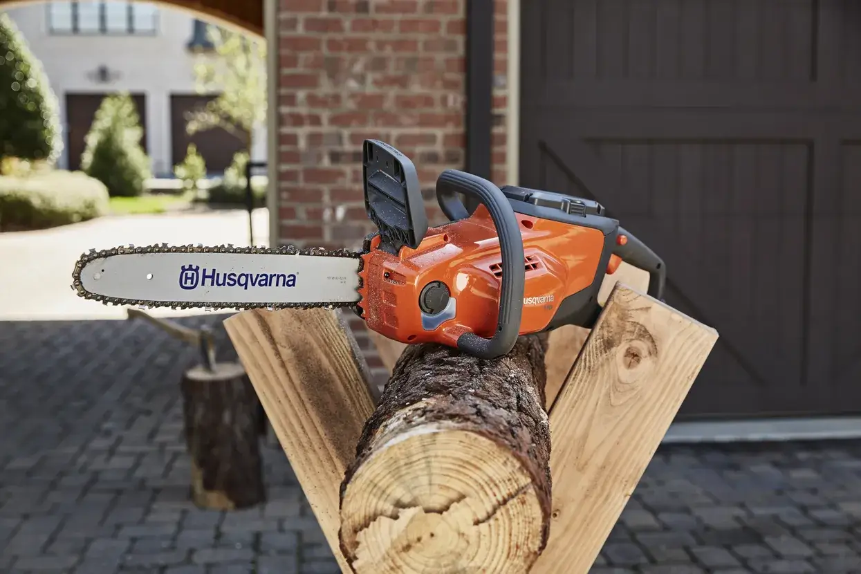 Husqvarna 120i en coupe sur une branche, batterie BLi en place