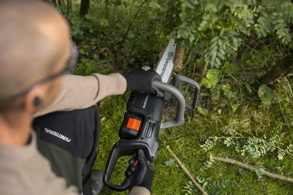 Husqvarna C15X-P4A en coupe sur une branche, batterie 18 V en place